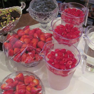 Healthy buffet desserts - iced spring water with fresh raspberries, blueberries, strawberries, dark chocolate and pistachios